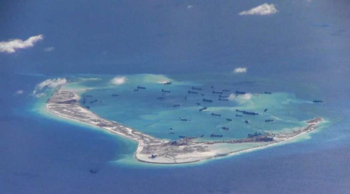 U.S. warships sail near South China Sea islands claimed by Beijing